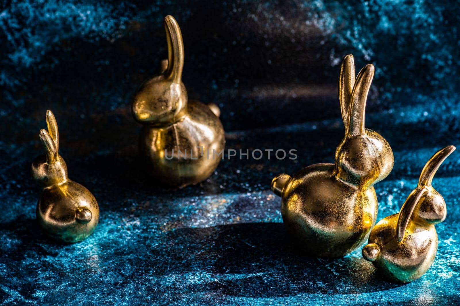 Easter card concept with golden bunnies on concrete background with copy space