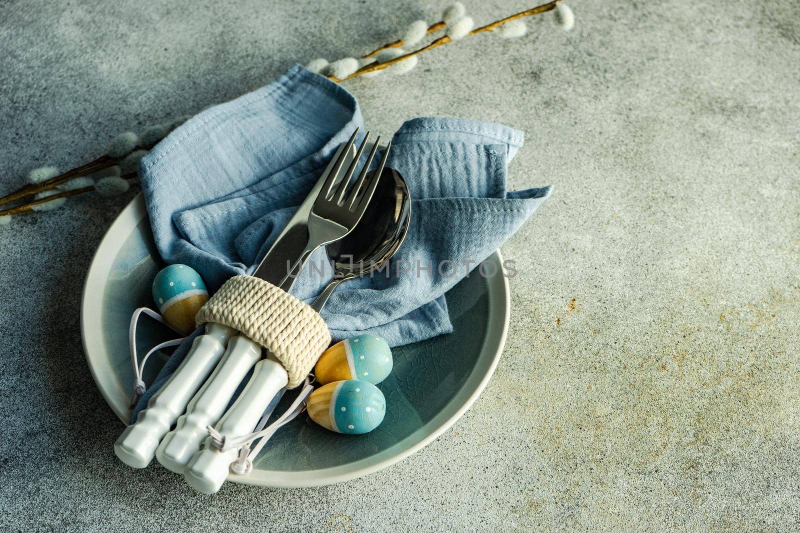 Table setting for festive Easter dinner served on concrete background