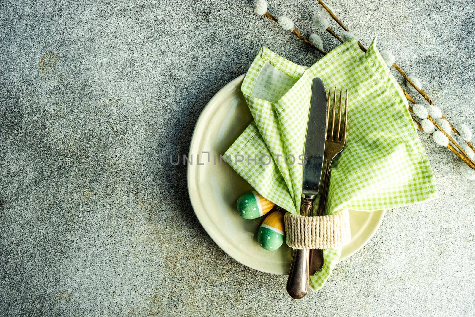 Table setting for festive Easter dinner served on concrete background