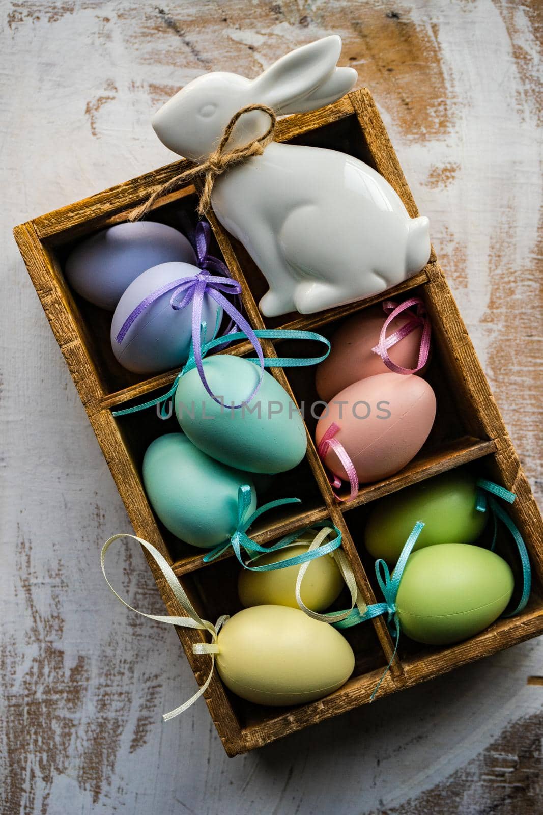 Box full of colorful eggs on rustic background