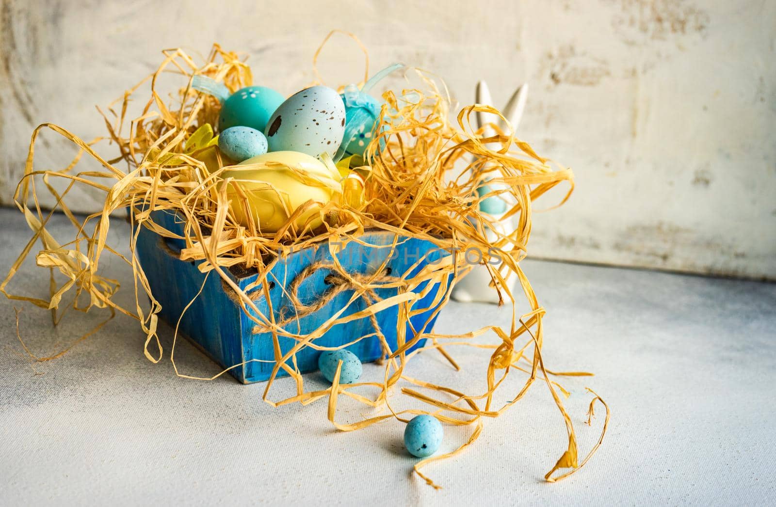 Box full of colorful eggs on rustic background