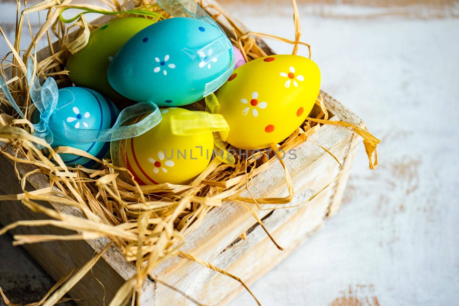 Box full of colorful eggs on rustic background