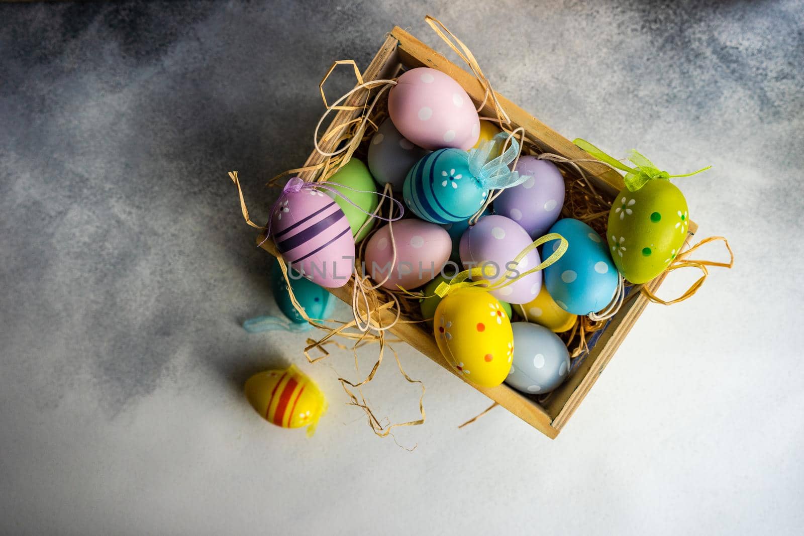 Box full of colorful eggs on rustic background