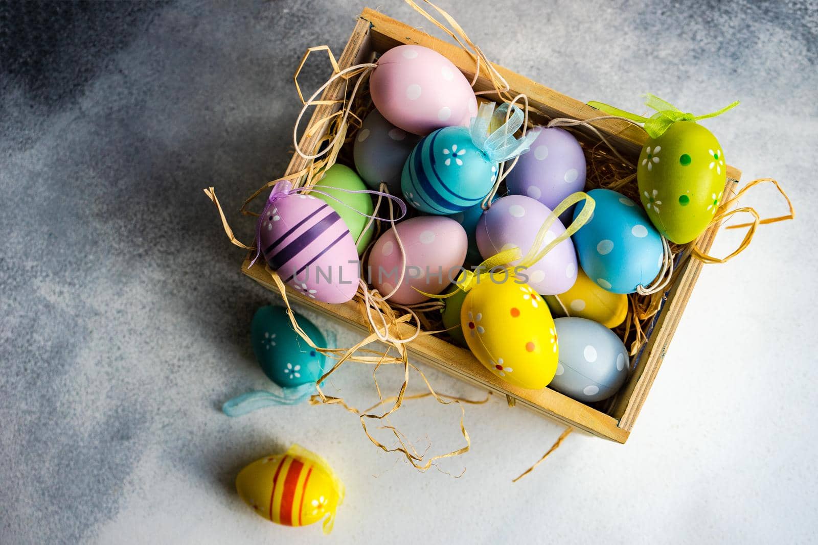 Box full of colorful eggs on rustic background