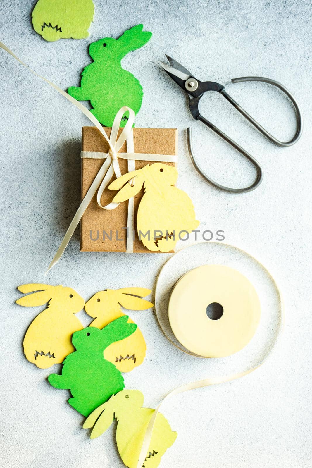 Easter card concept with wooden bunny decoration and gift box on concrete background