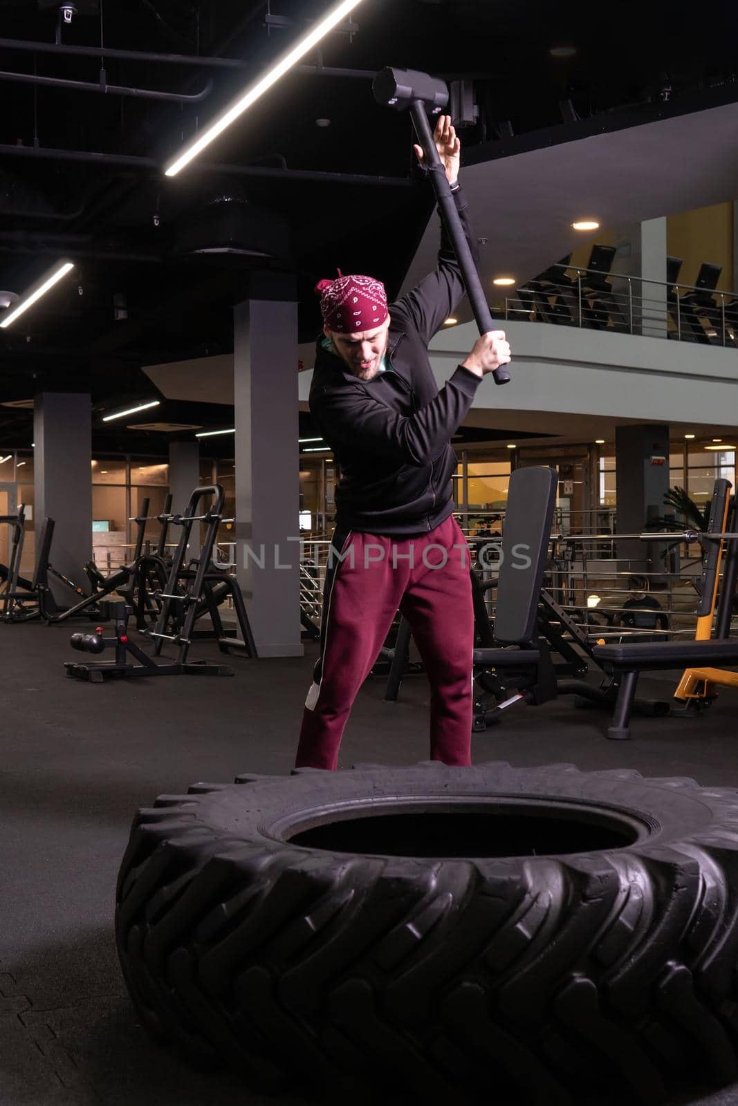 A man hits a sledgehammer wheel in fitness, the concept of a healthy lifestyle male sledgehammer active hit sport, for fitness exercise for athlete and bodybuilder workout, strike ethnic. Skinned dedication ethnity, portrait by 89167702191