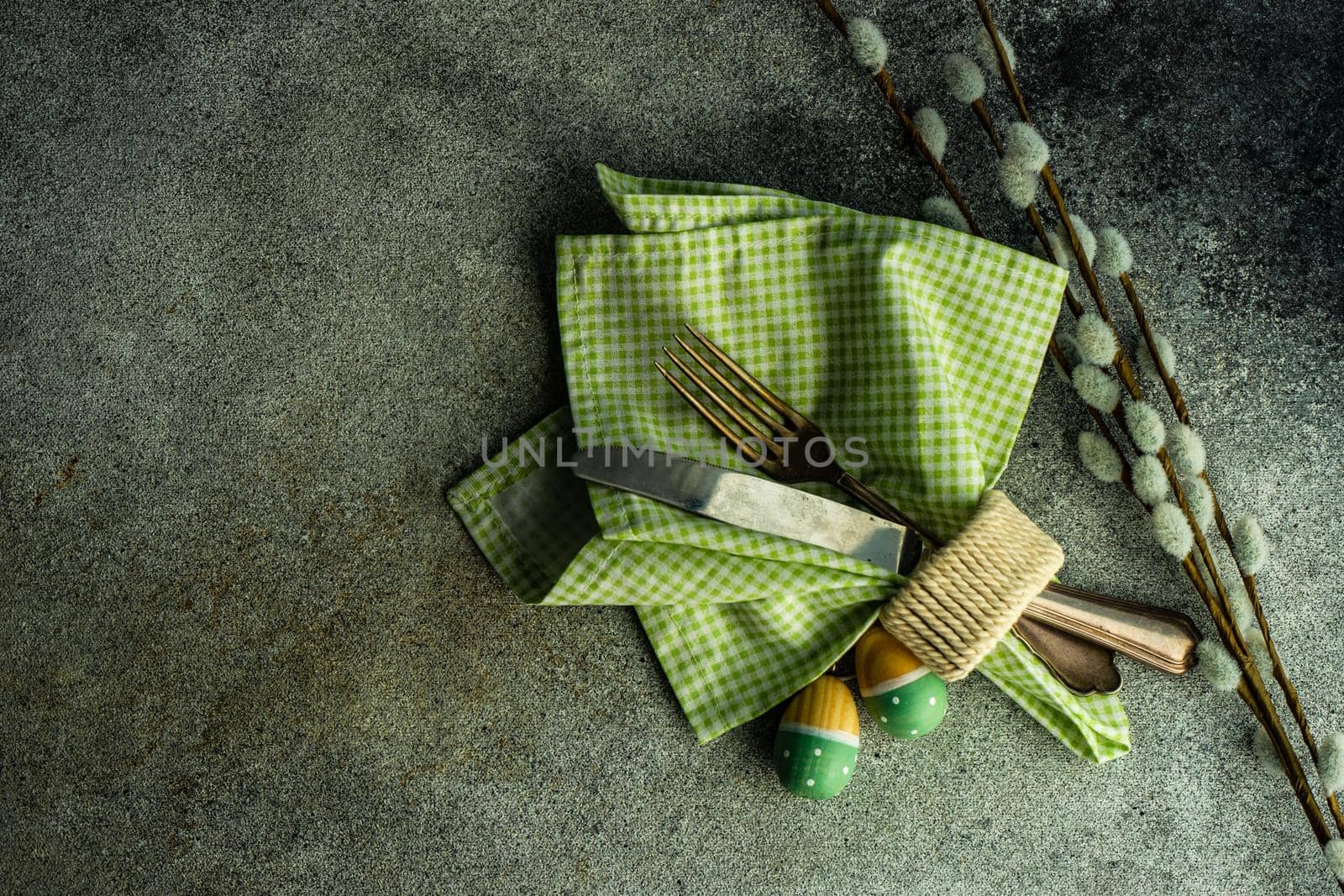 Table setting for festive Easter dinner served on concrete background