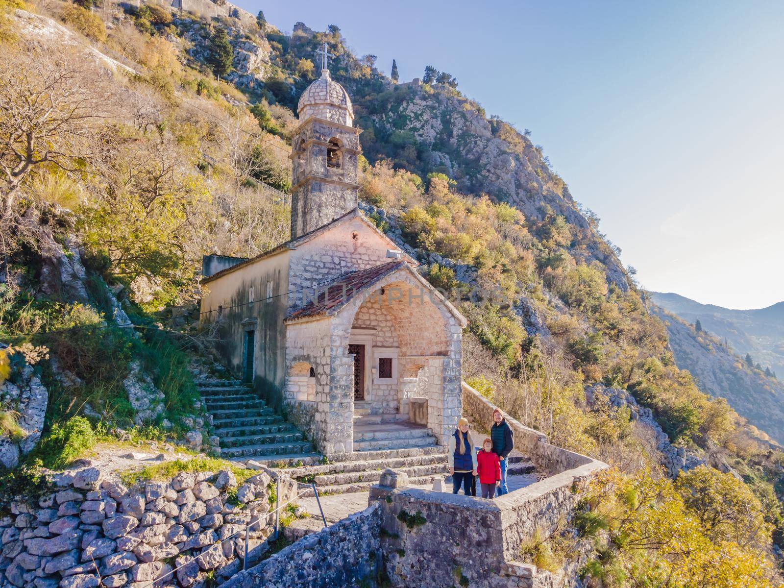 Family of hikers on Hiking in Kotor Old Town Ladder of Kotor Fortress Hiking Trail. Aerial drone view by galitskaya