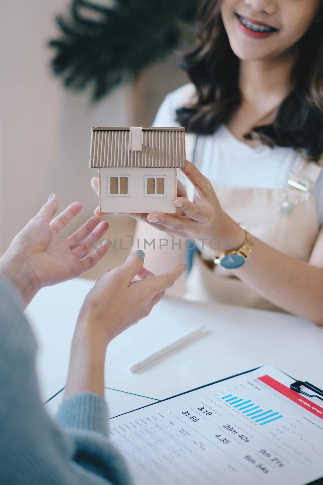 Close up of Business woman giving house after signing agreement for buying house. Bank manager and real estate concept