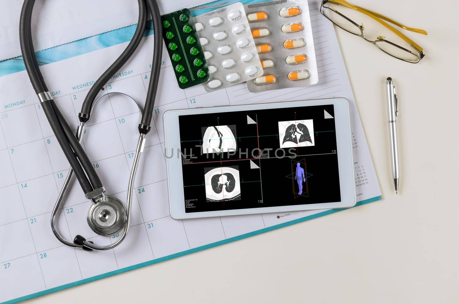 Medicall office report of MRI scan of the patient with stethoscope in showing in digital tablet and pills of doctor workplace