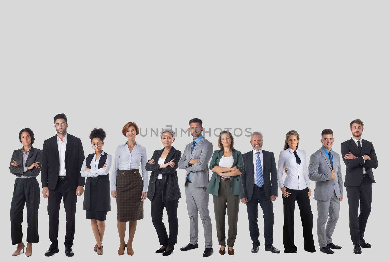Full-length portrait of group of business people, isolated on gray background, copy space for text. Concept of teamwork and cooperation