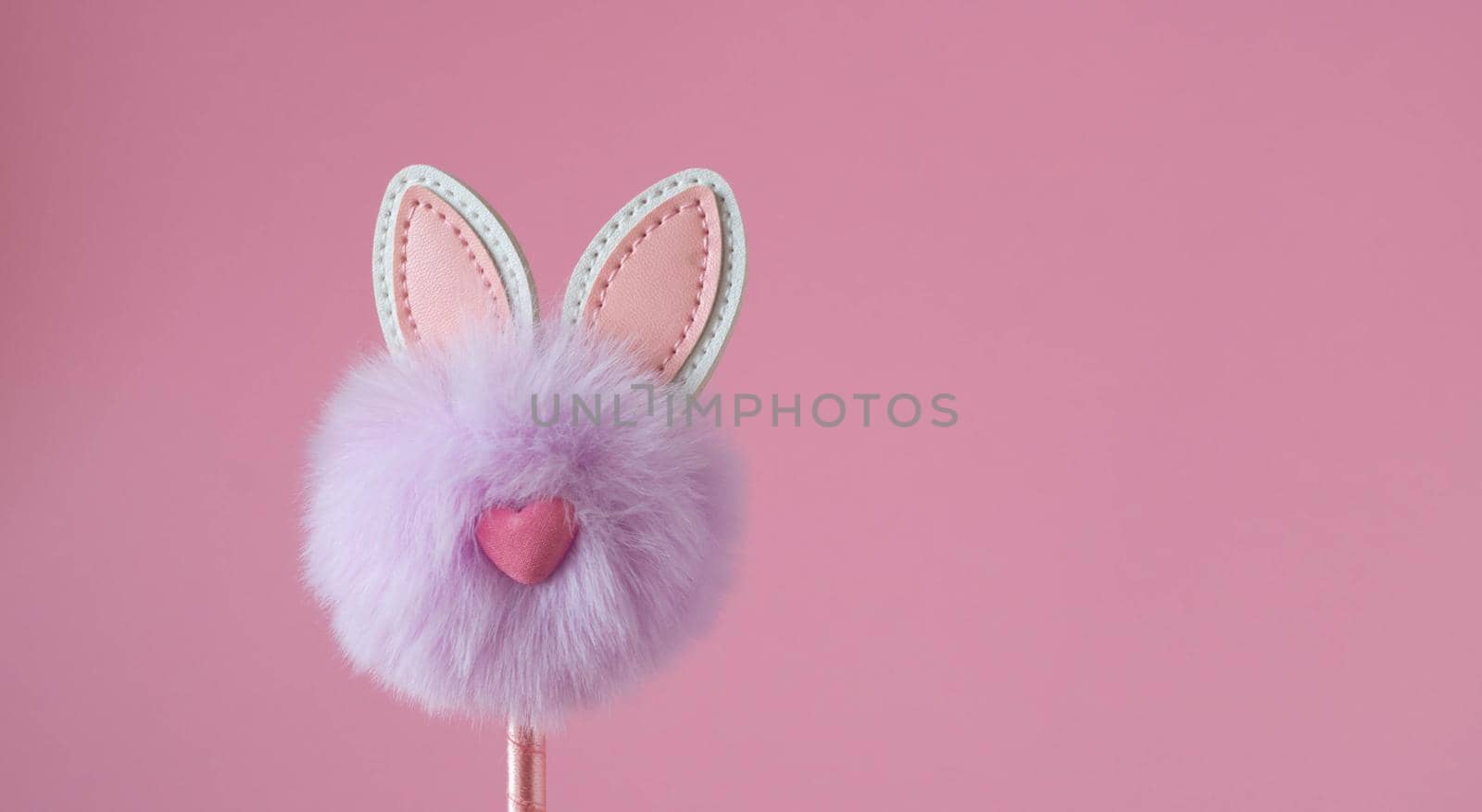 Cute little fluffy lilac bunny toy on pink background. Easter Concept.