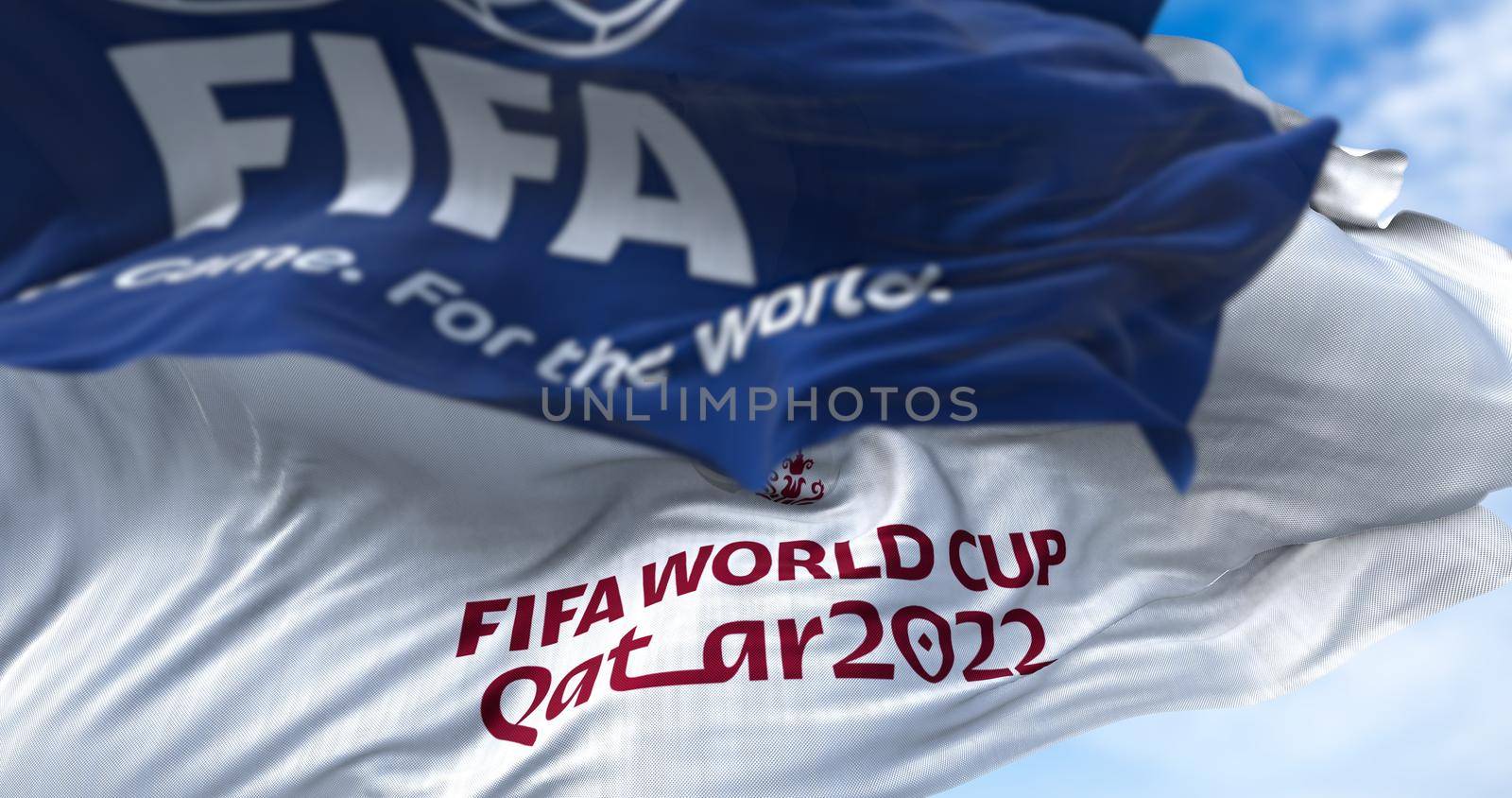 Doha, Qatar, January 2022: Flags with FIFA and Qatar 2022 World Cup logo waving in the wind. The event is scheduled in Qatar from 21 November to 18 December 2022