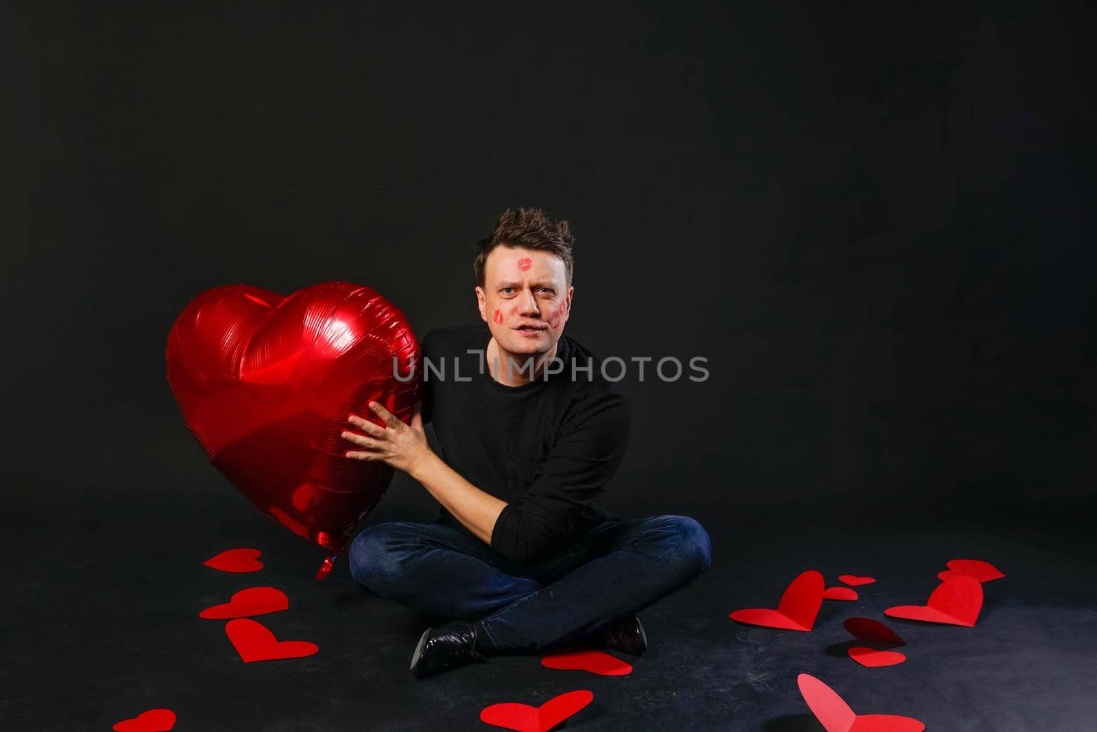 valentines red heart, balloon in hands, photogenic heterosexual. On black background lifestyle guy giving