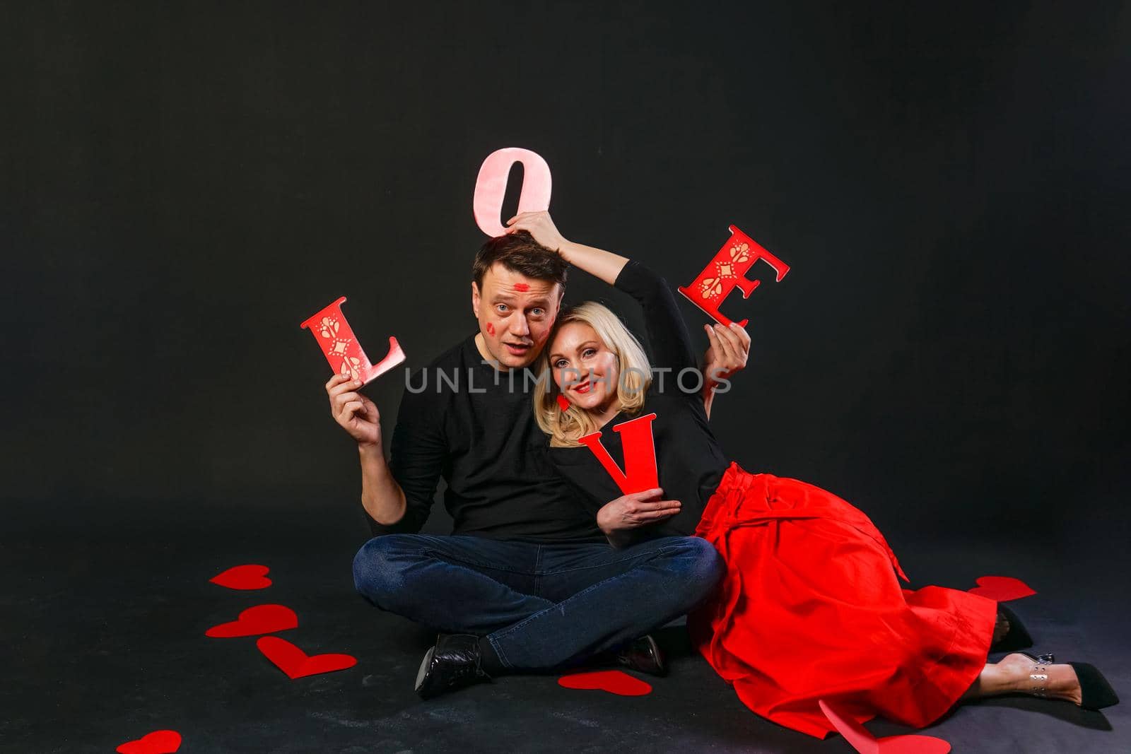 Family keeps the word LOVE love red, Valentines day board, on the floor hearts lovely space. the banner formula copy of space forever, joy in a red dress girl barefoot