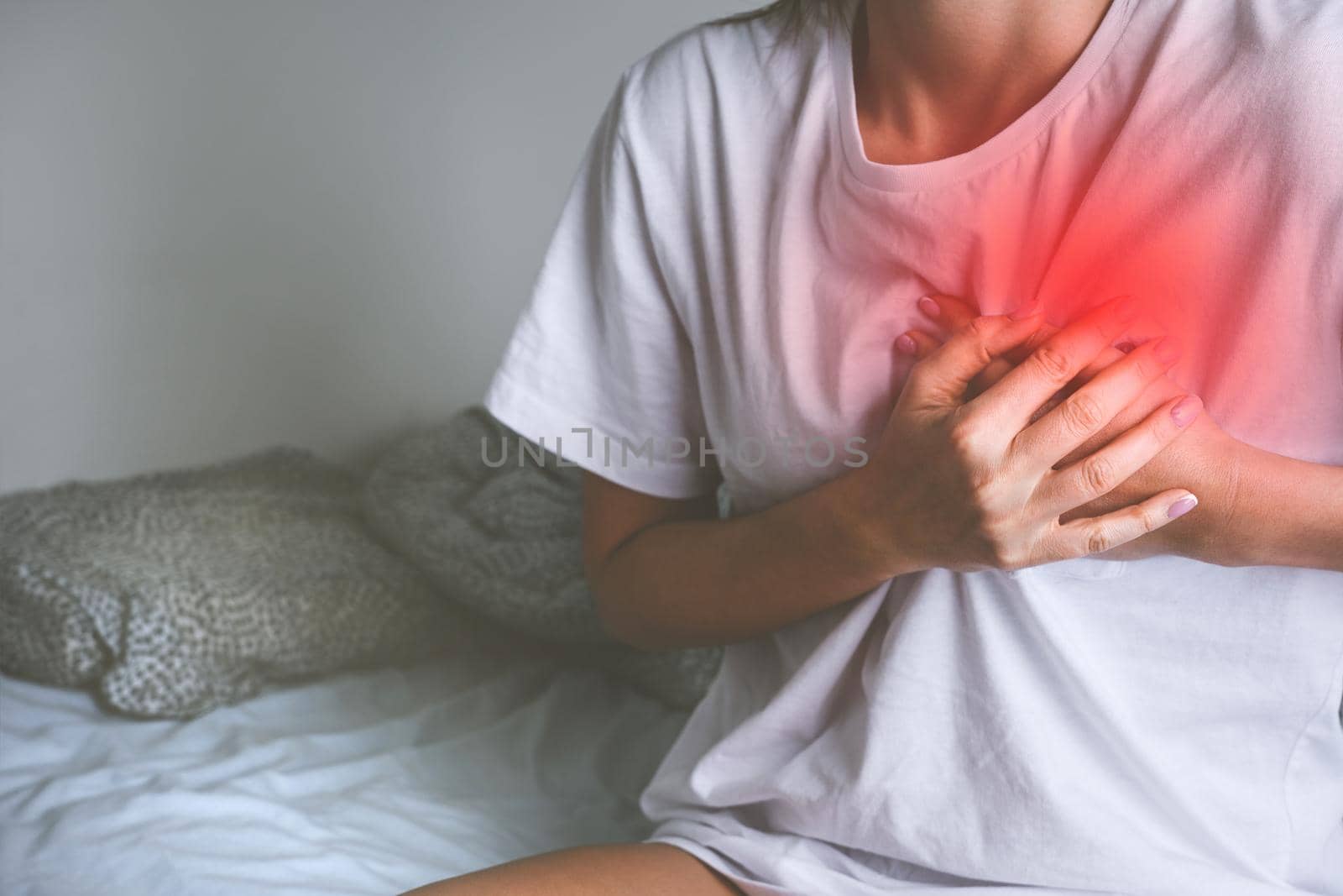 Woman holding chest because of acute heart pain or chest pain. Heart disease and heart attack symptom. High quality photo