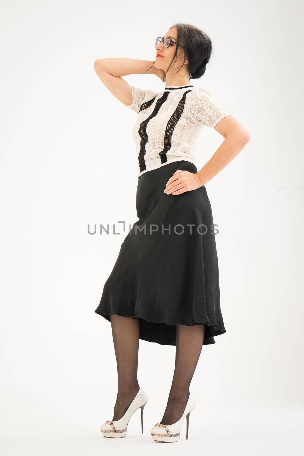 Studio photo of middle aged woman starting getting grey-haired wearing black and white clothes on white background, middle age sexy lady, happy life concept.