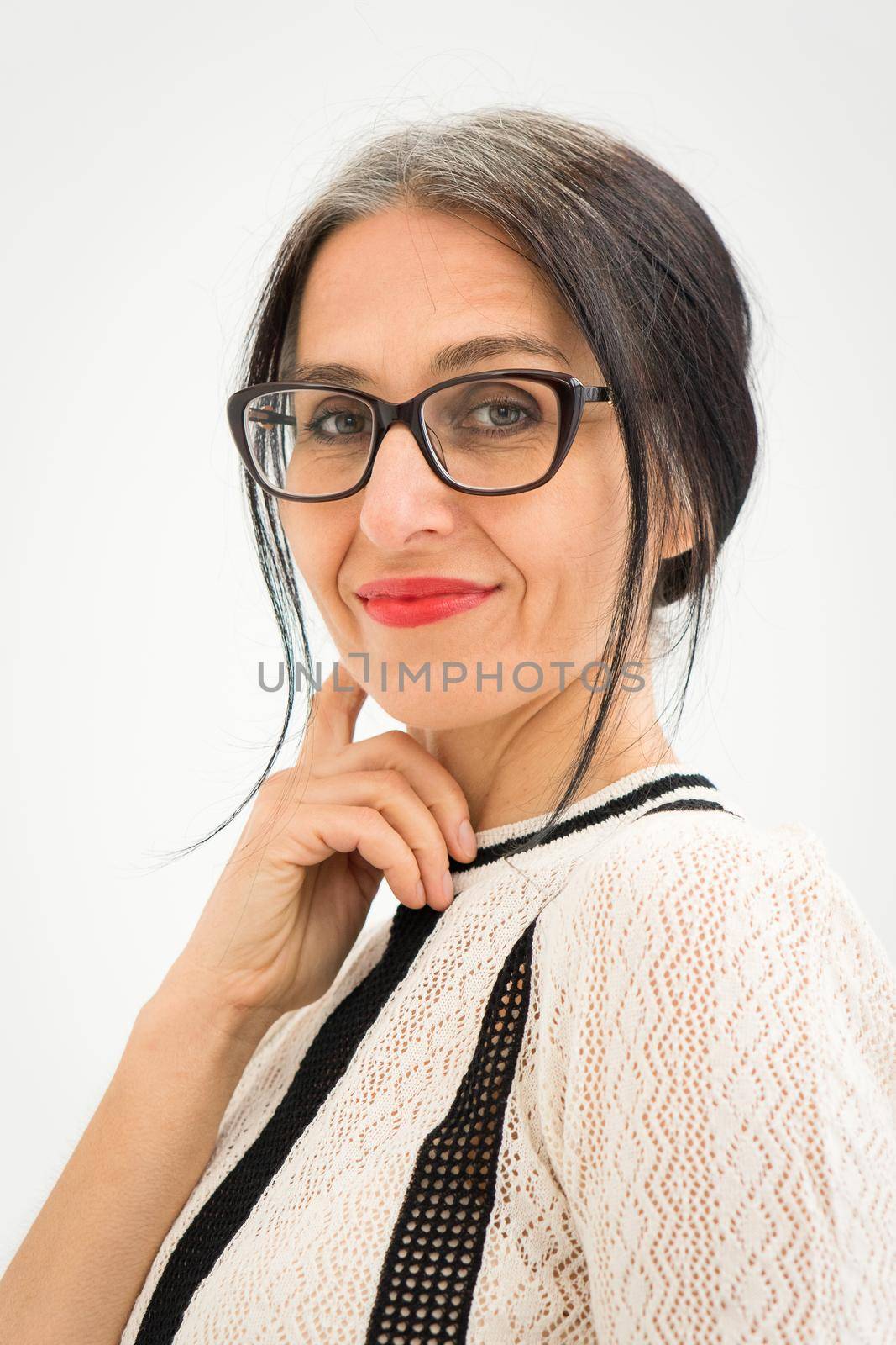 Studio photo of middle aged woman starting getting grey-haired wearing black and white clothes on white background, middle age sexy lady, happy life concept by balinska_lv