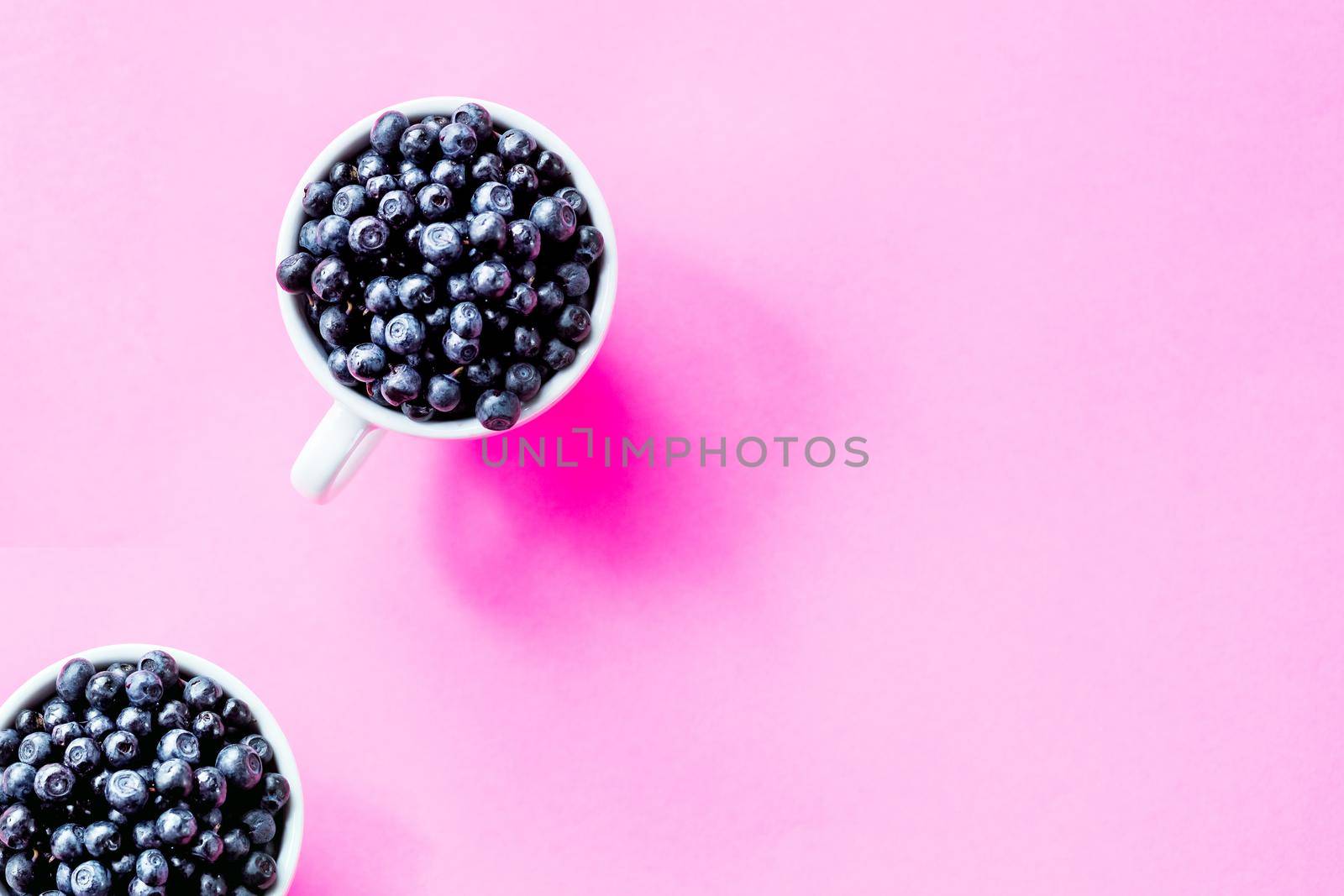 Art Nouveau style concept image, White cup full of blueberries on a colored geometric trendy background, food and healthy concept