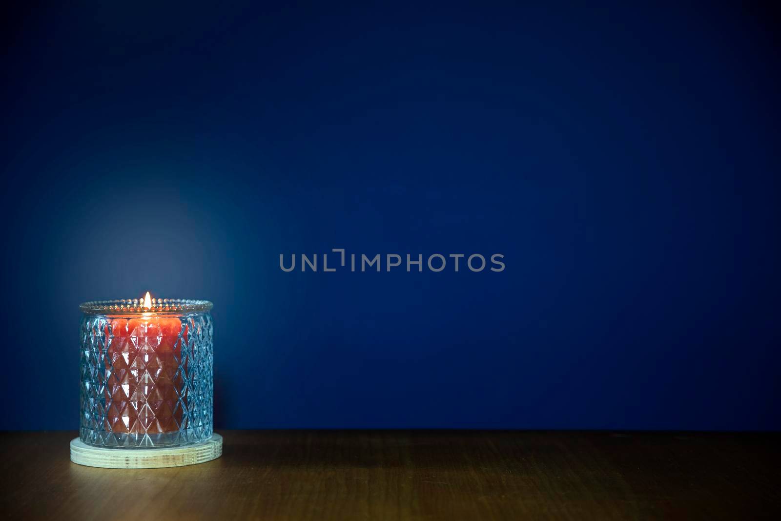 Burning candles on wooden table against dark blue background with copy space. stylish home decoration, space for text