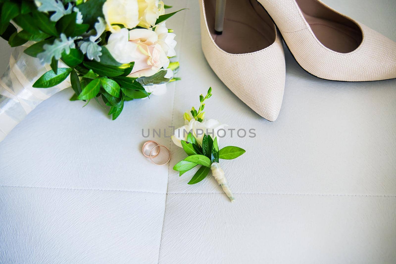 Wedding accessories: shoes, rings, boutonnieres perfume on a white background