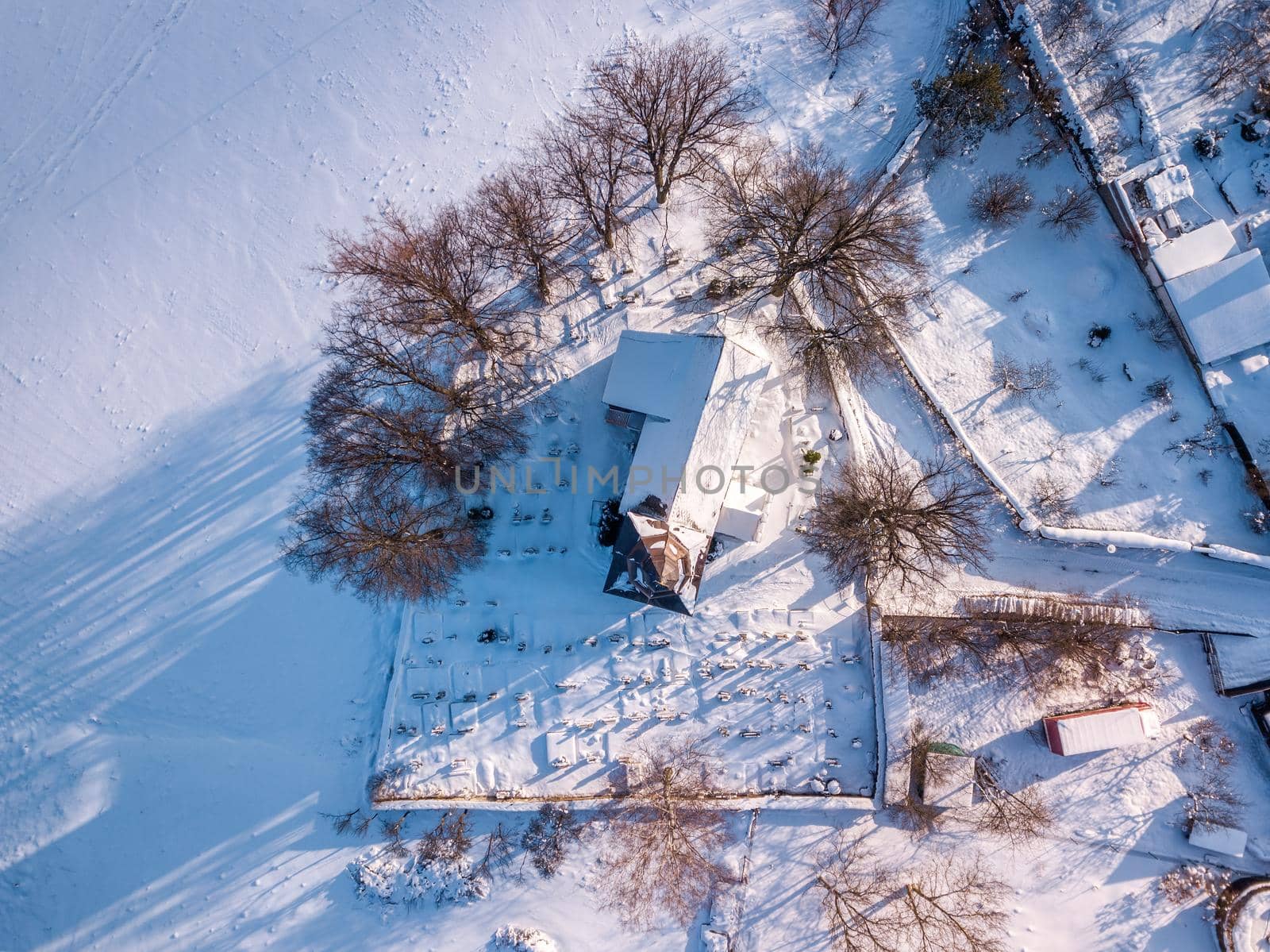 Top view of Small Church covered by snow in sunny day in Petrovice, Vysocina, Czech Republic