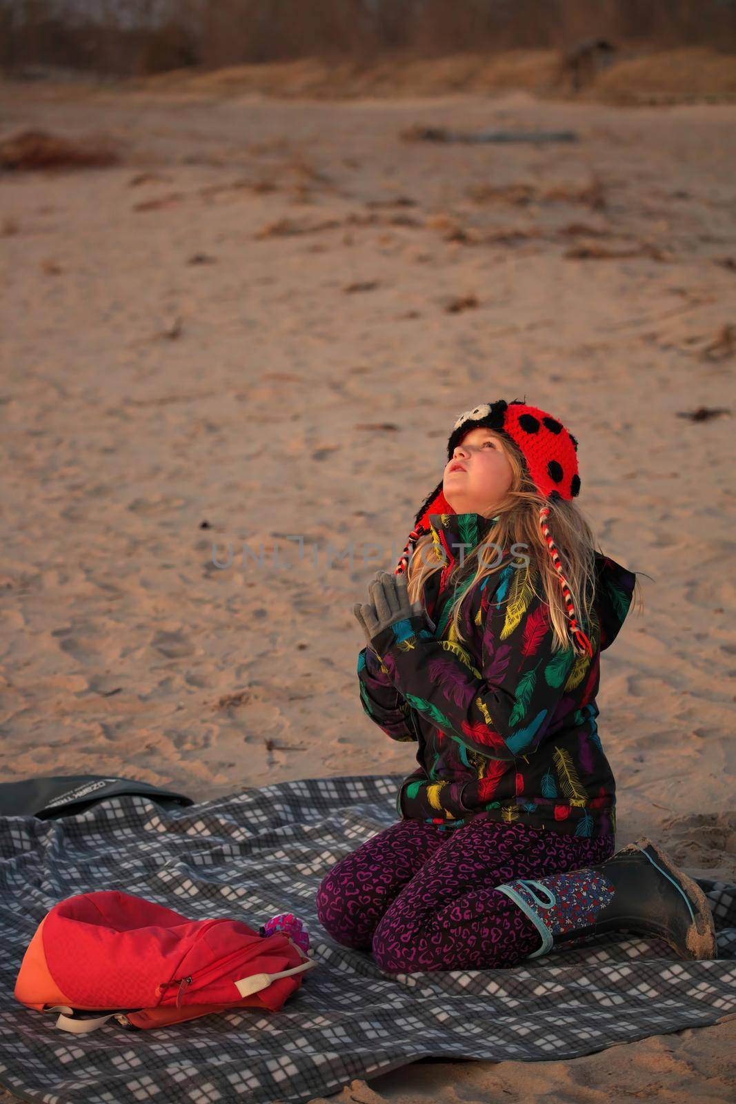 A young girl makes a wish on the first star at the beach by markvandam