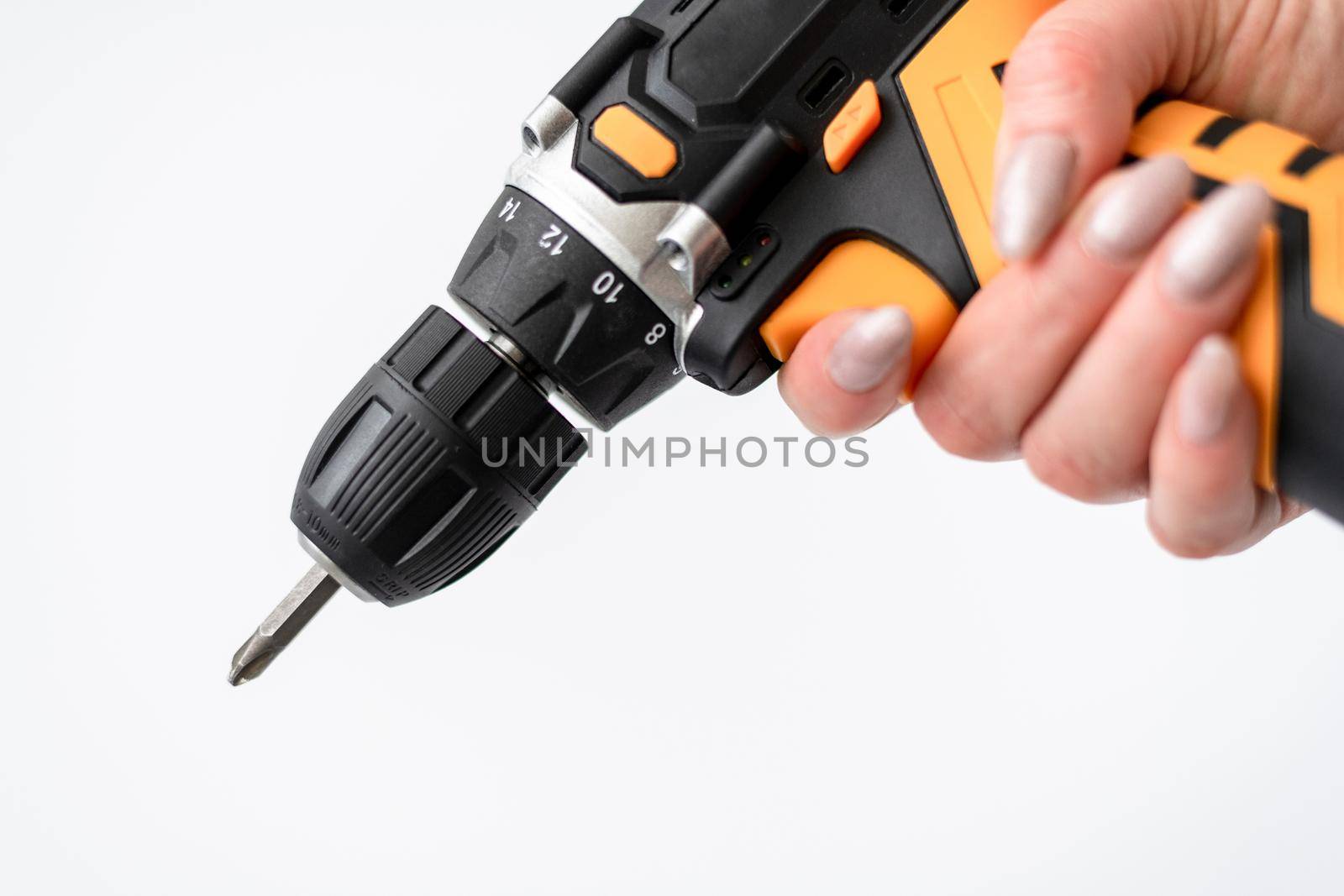 Screwdriver in a female hand on a white background by olgavolodina