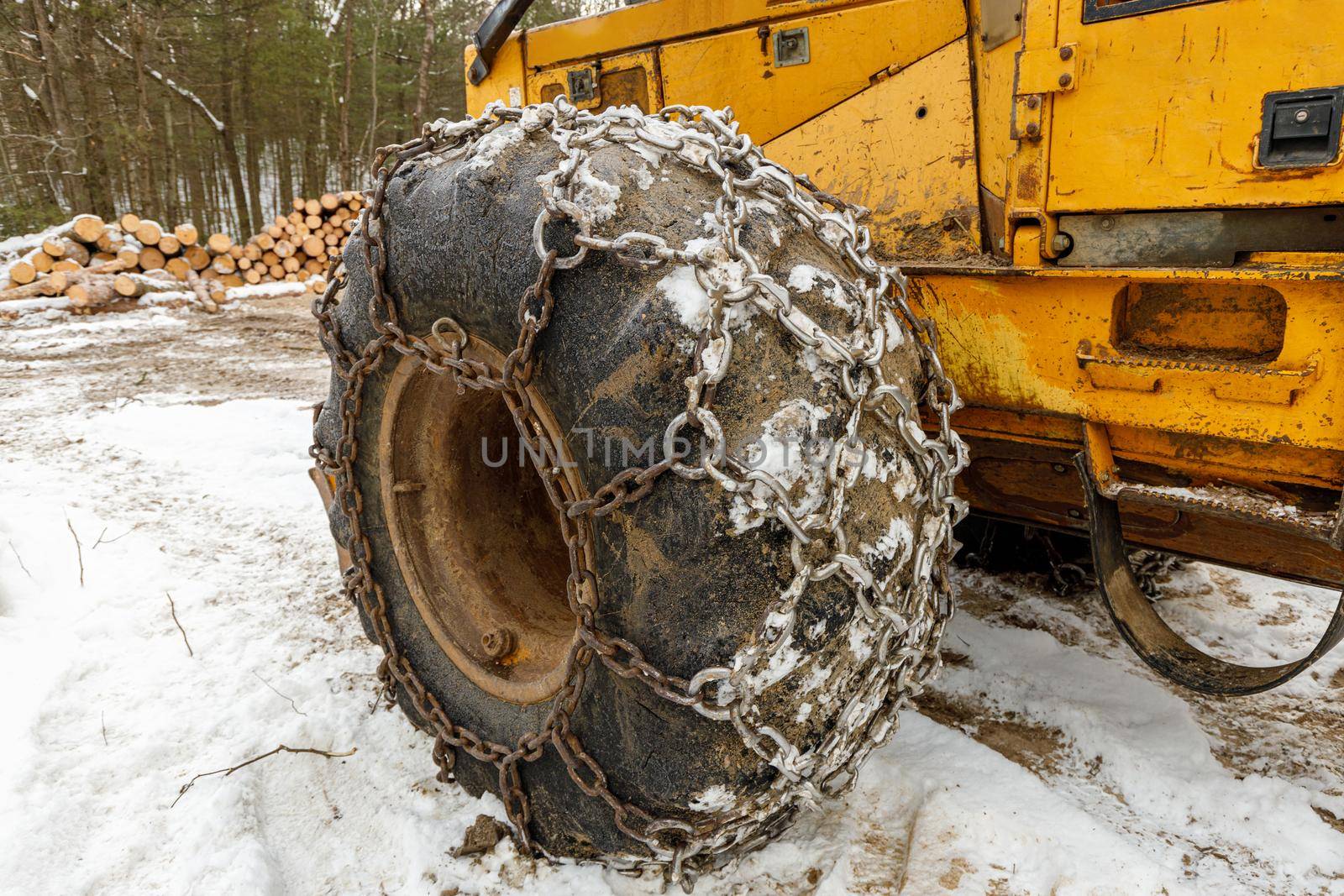 Close up of Winter Chains on Yellow Logging Skidder for extra grip in the snow . High quality photo
