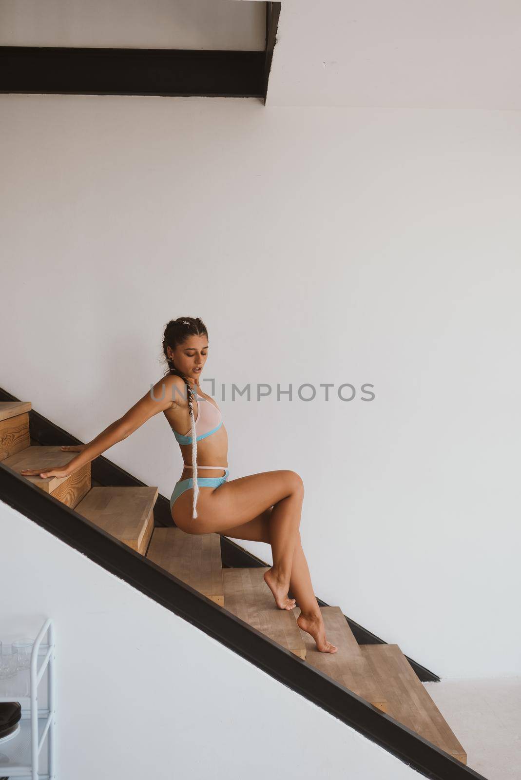 Sexy girl posing on the steps in the lingerie. Side view