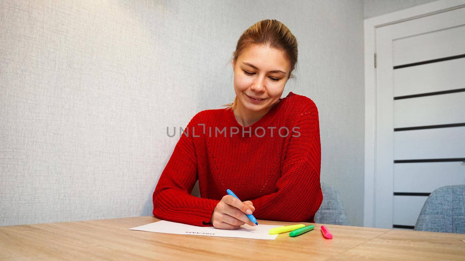 Portrait of young beautiful thoughtful lady writing down her dreams list. Visualization of dreams