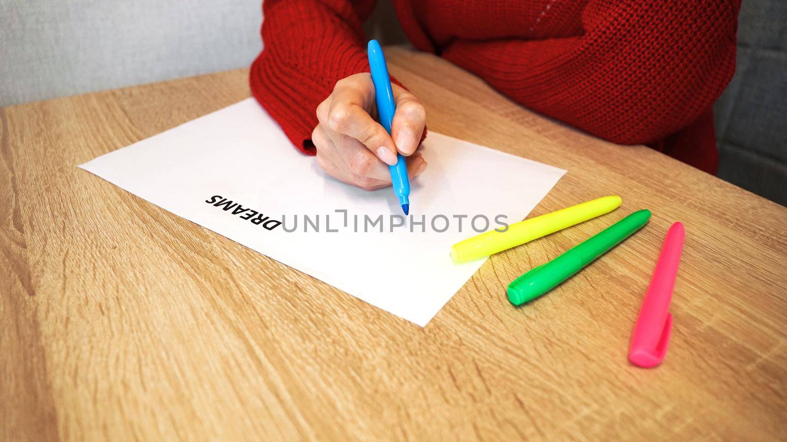 Woman writing down her dreams list by colored markers. Visualization of dreams