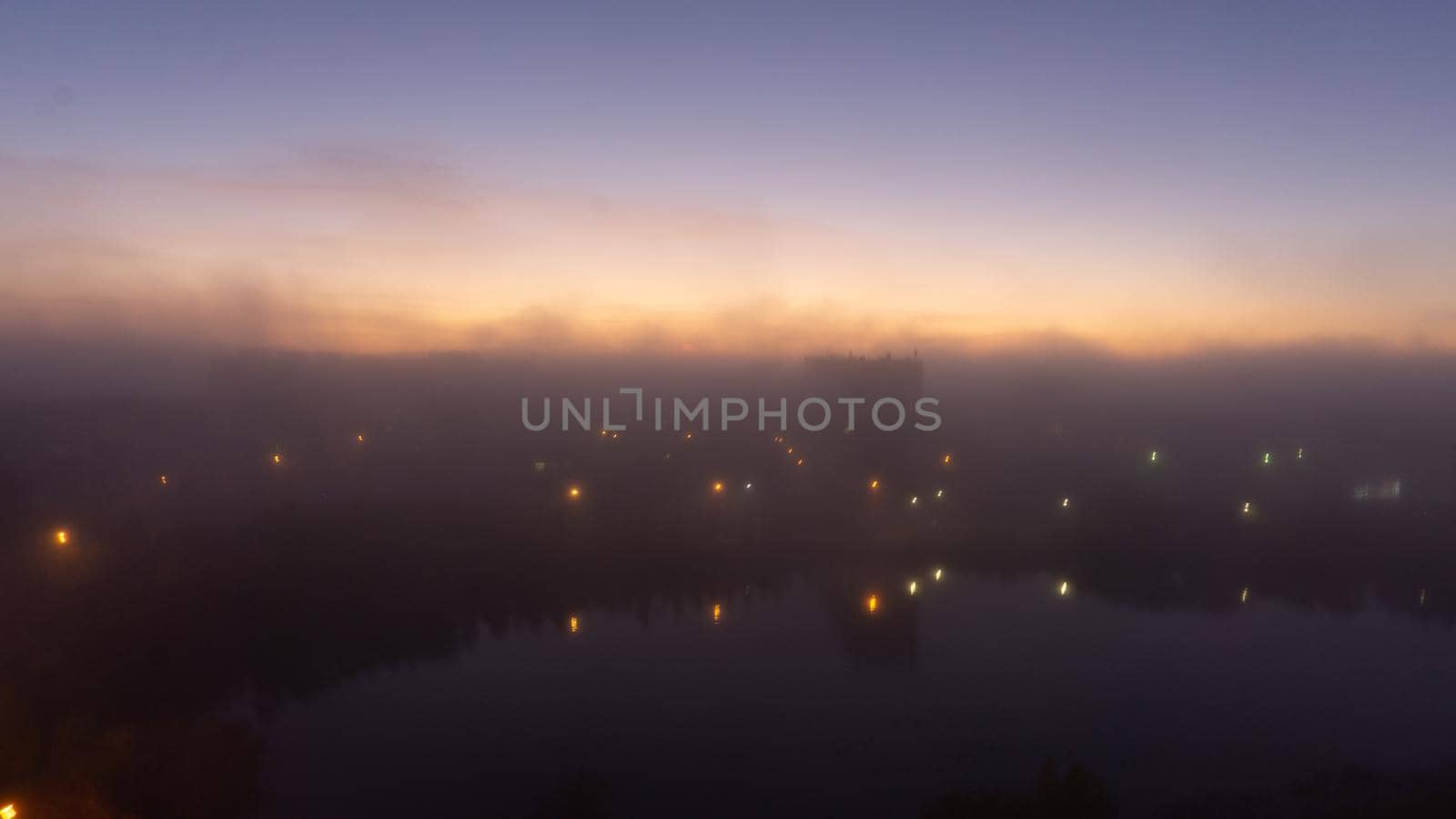 SEVERODVINSK, RUSSIA - MARCH, 11, 2021: Bright winter sunset against the background of houses. Multi-story houses in the rays of the sun. The sun goes down behind the houses