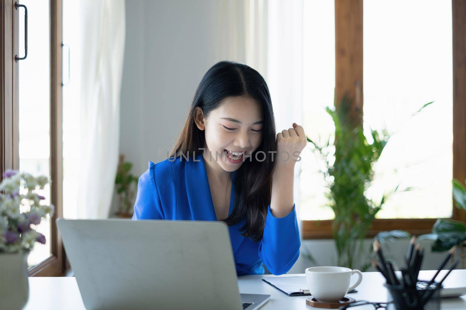 Asian Woman blogger wear blue suit talking with followers, live streaming on social media application. Freelance work from home concept