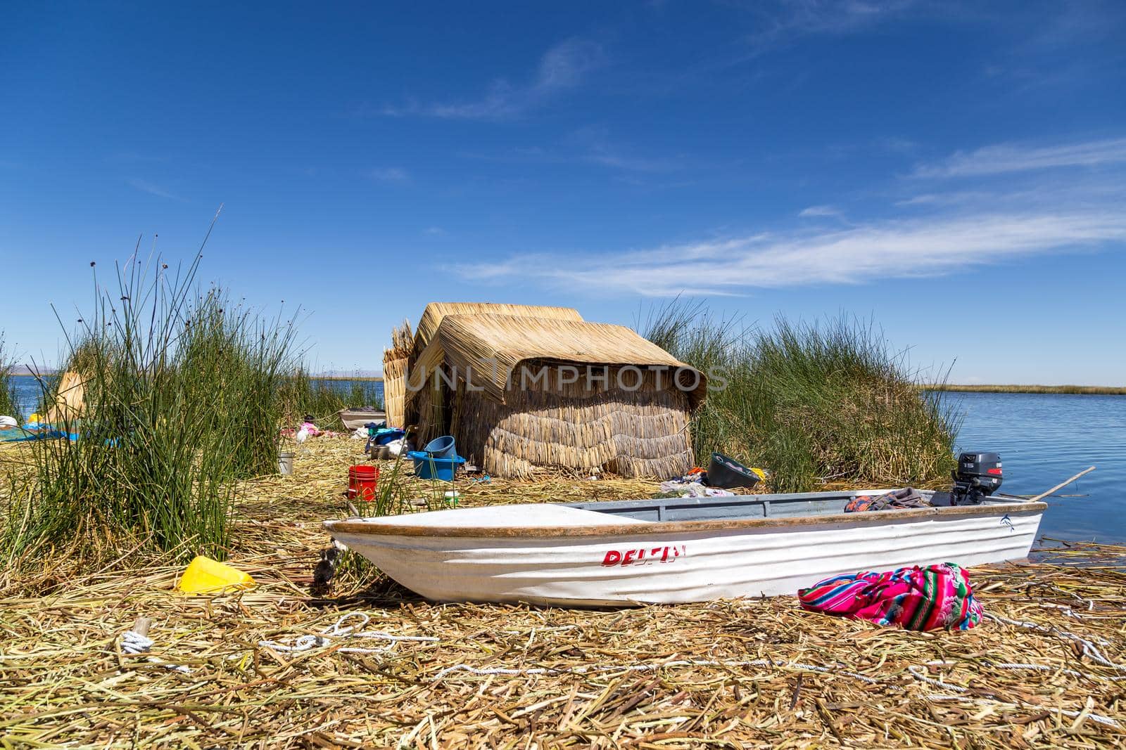 Titicaca Lake, Peru - October 14, 2015: Straw huts and a boat on one of the Titino Floating Islands on the Titicaca Lake.