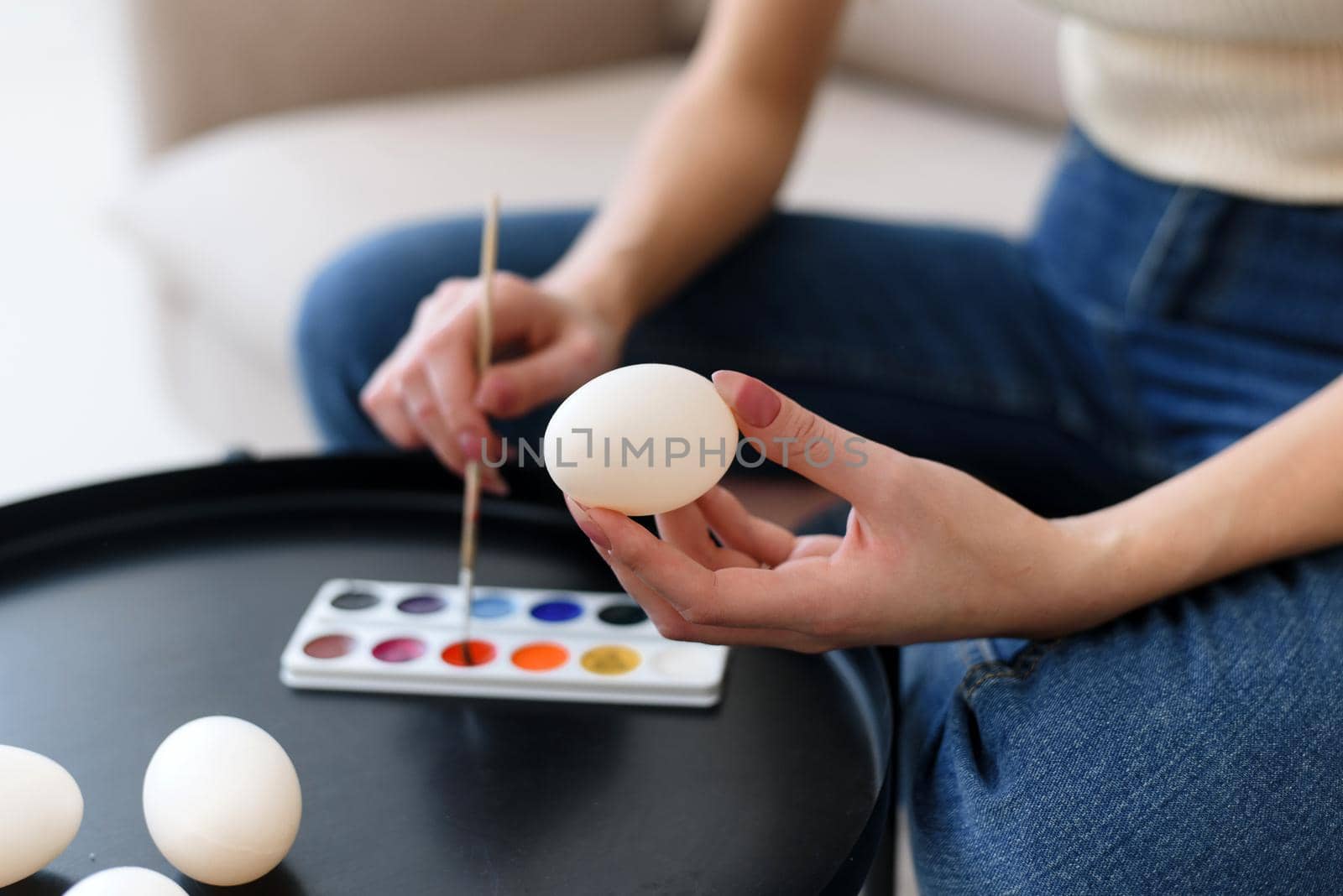 Easter, holiday concept - Young mother painting eggs for easter.