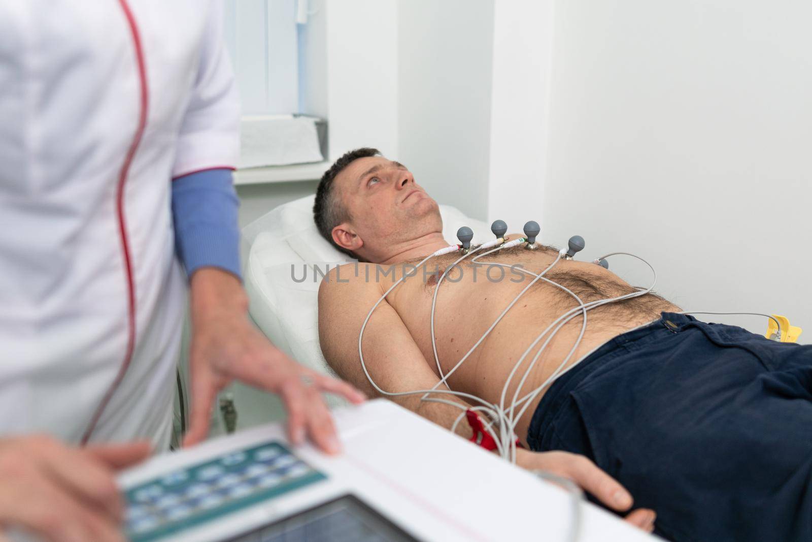 Medical equipment for electrocardiogram. Doctors doing ECG test on male patient. Diagnostic heart disease heart attack, tachycardia. Electrocardiography procedure. Cardiologist doing check-up test.