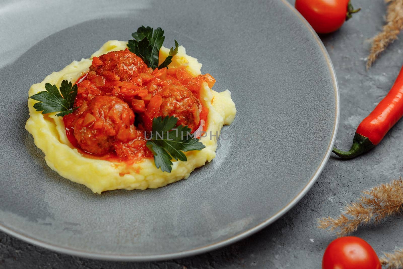 Meatballs in tomato sauce with mashed potato on the white plate, top view, view from above.