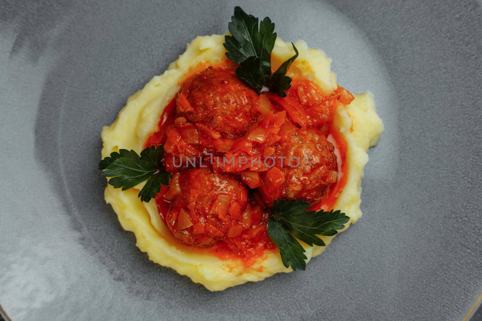 Meatballs in tomato sauce with mashed potato on the white plate, top view, view from above.
