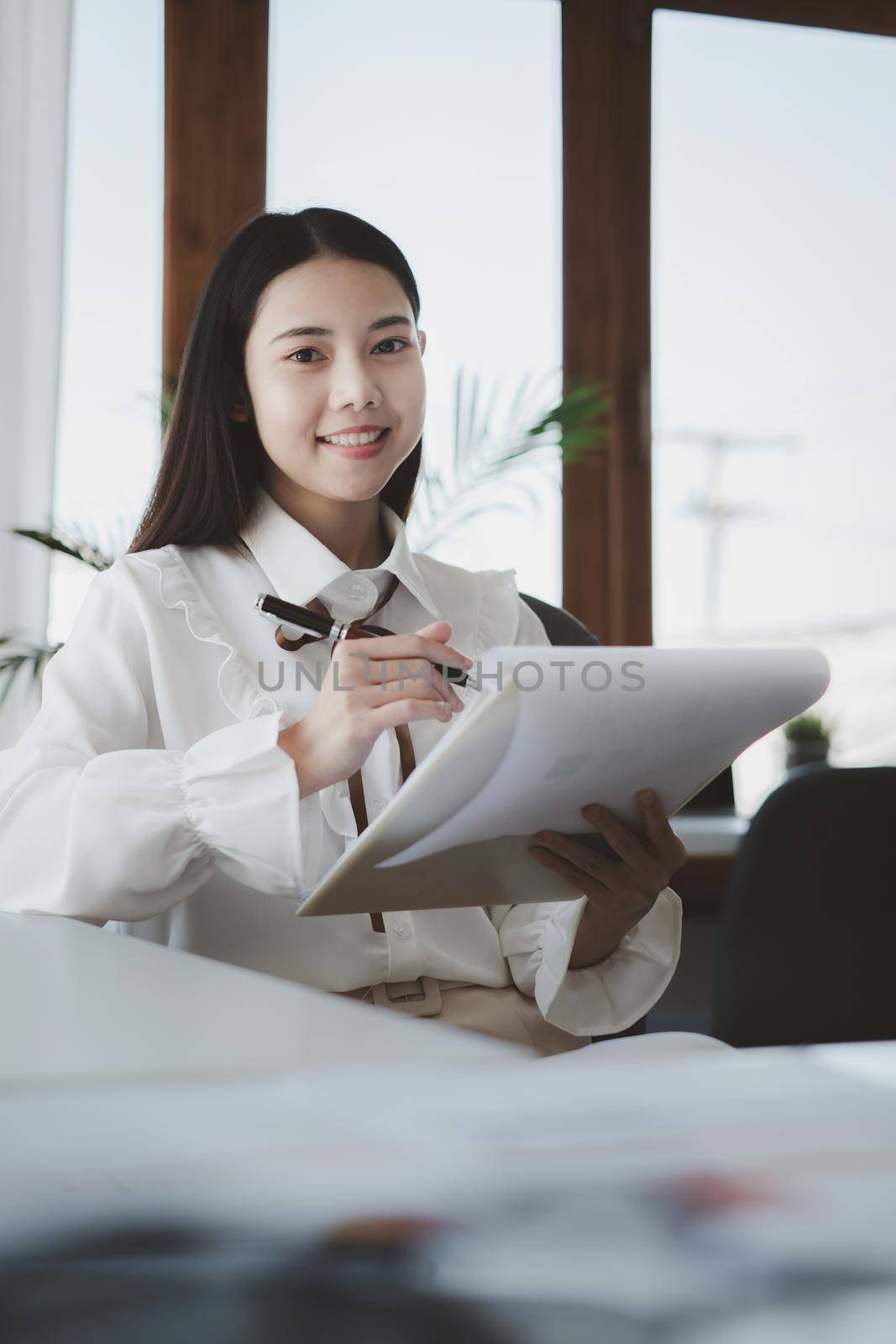 Asian Businesswoman or Accountant hands holding paperwork with calculator, account and saving concept. by itchaznong