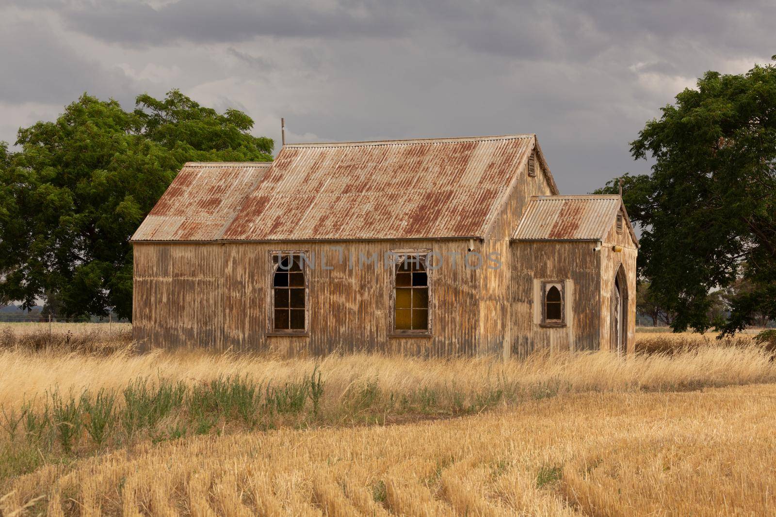 Rustic old abandoned church in rural NSW Australia with recently harvested crop