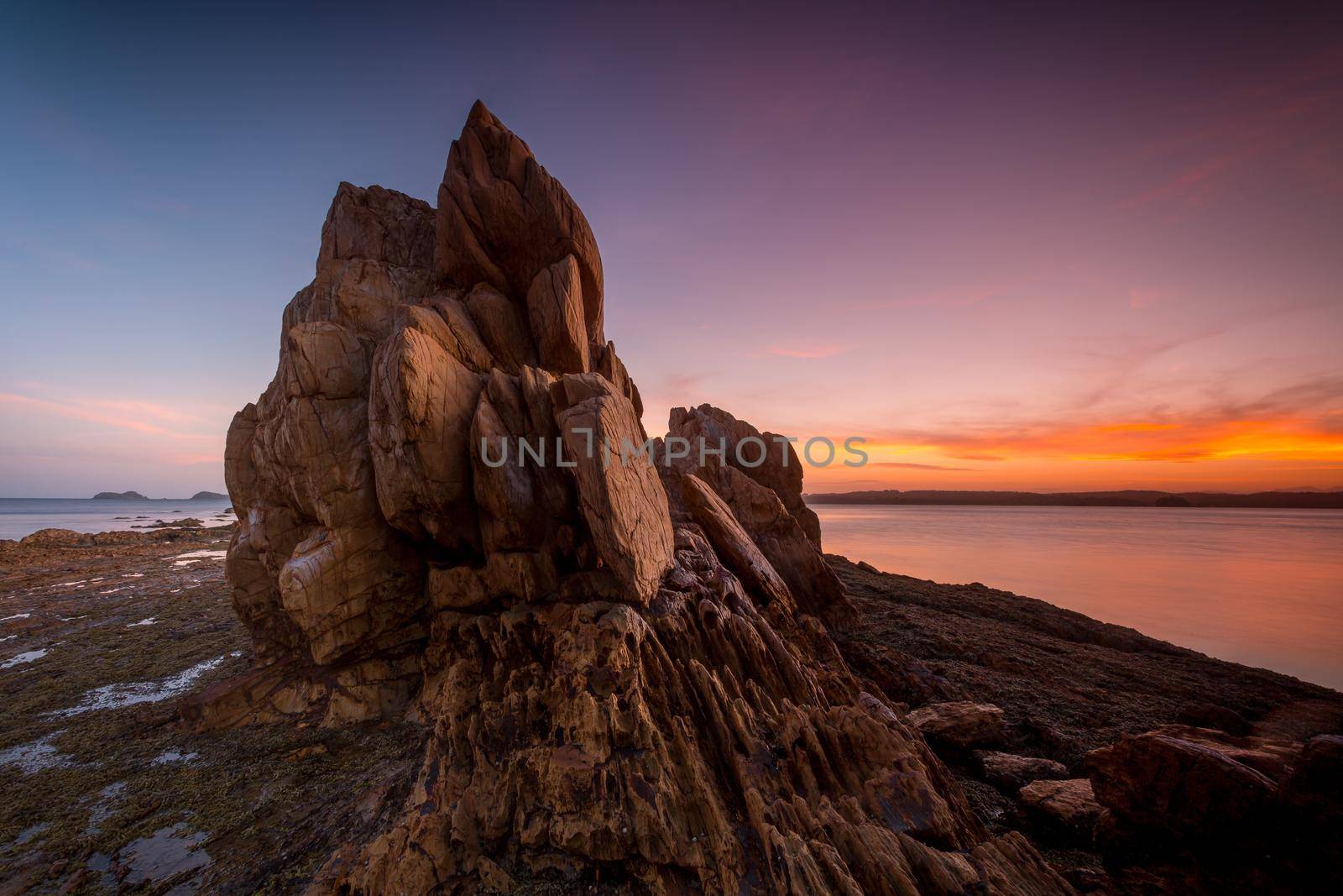 Tranquil sunset over rocky tor Batemans Bay Australia by lovleah