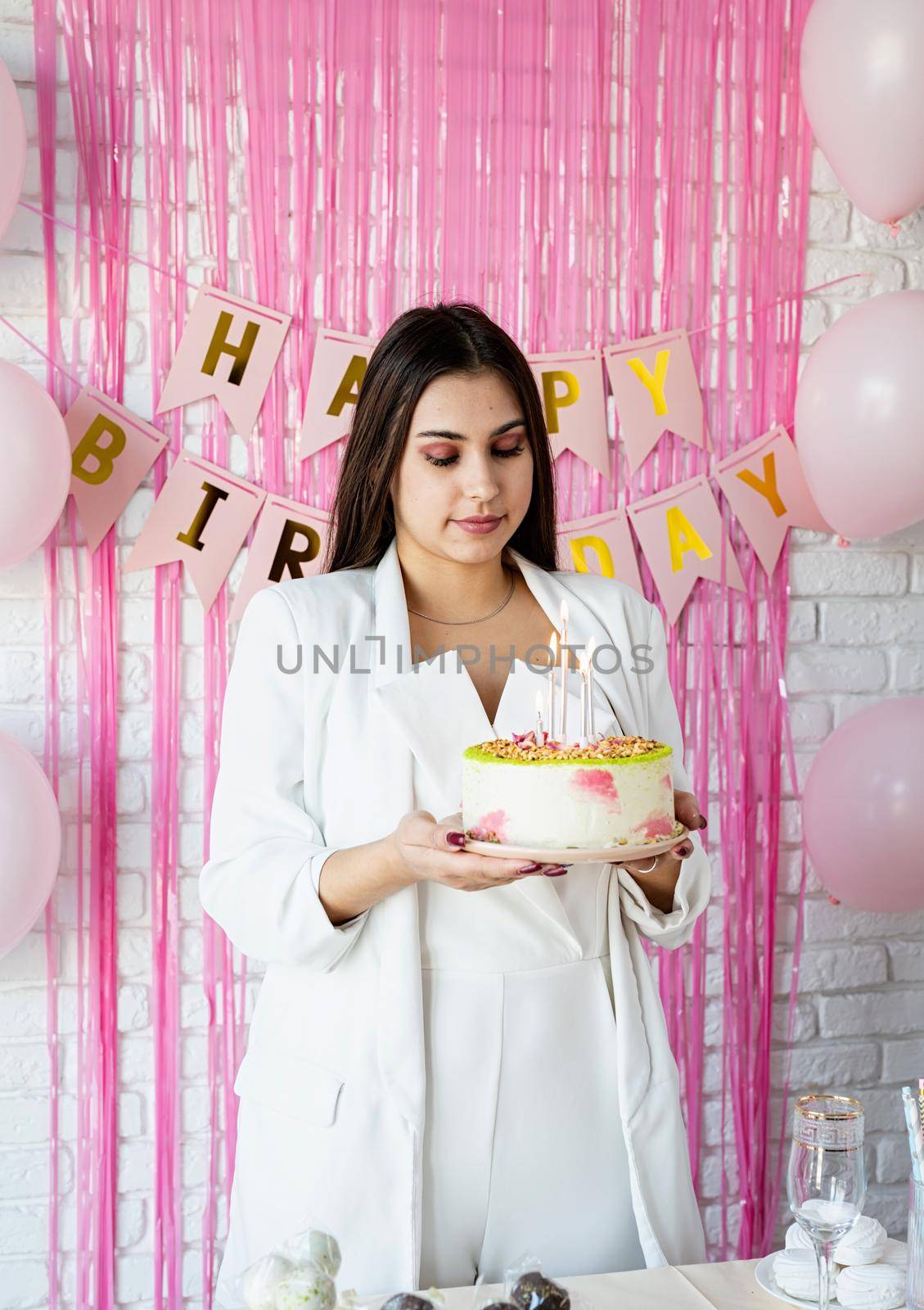 Beautiful woman celebrating birthday party holding a cake by Desperada