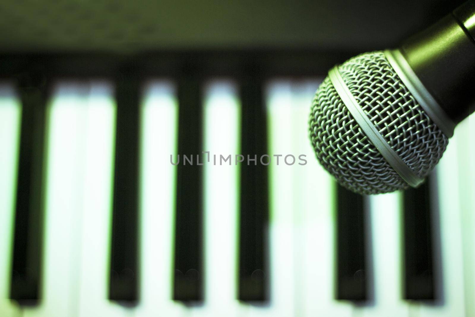 Microphone over piano keys in dim light by GemaIbarra