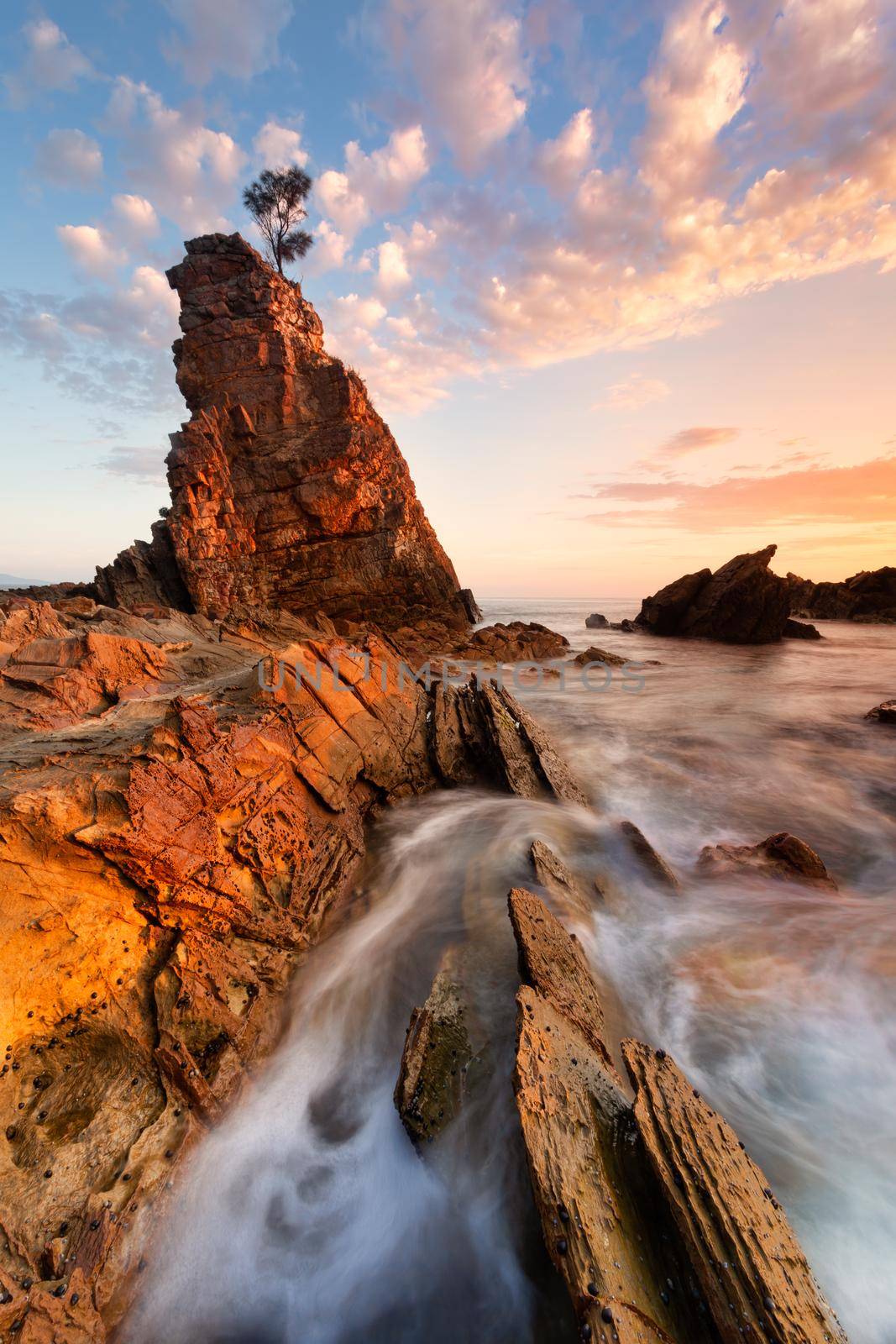 Tall pinnacle rock with cotton candy clouds after sunrise Australia by lovleah