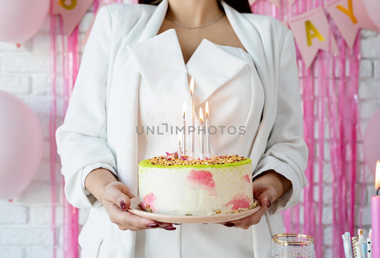 Beautiful woman celebrating birthday party holding a cake by Desperada