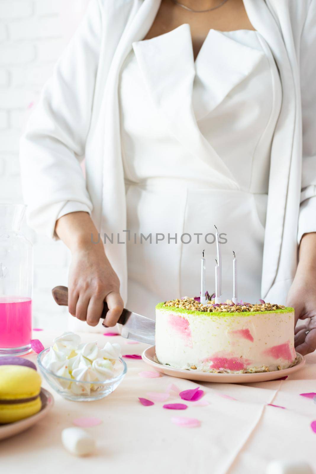 Beautiful woman celebrating birthday party cutting a cake by Desperada