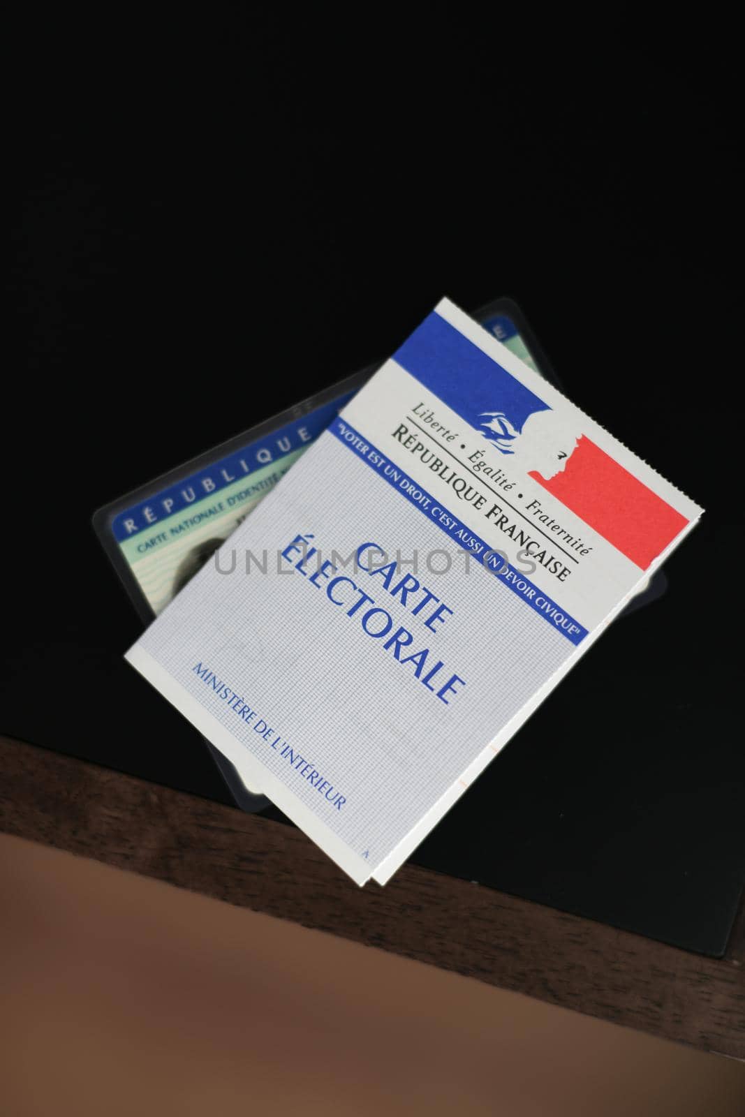 PARIS, FRANCE - MARCH 09, 2020: Hand holds a french electoral card and an identification card for voting by Godi