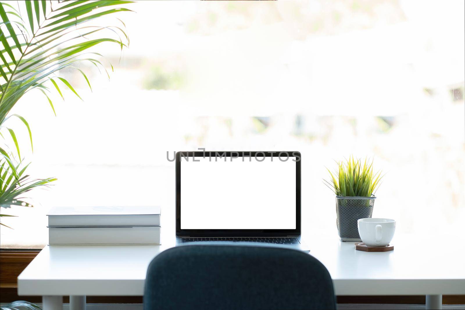 Mockup image of laptop computer with blank white screen on working space at home office.