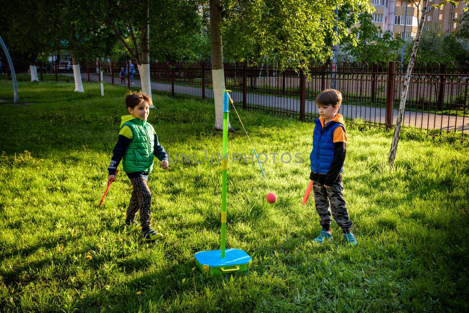 Two friends are playing tetherball swing ball game in summer camping. Two boy brother happy leisure healthy active time outdoors concept by Kobysh